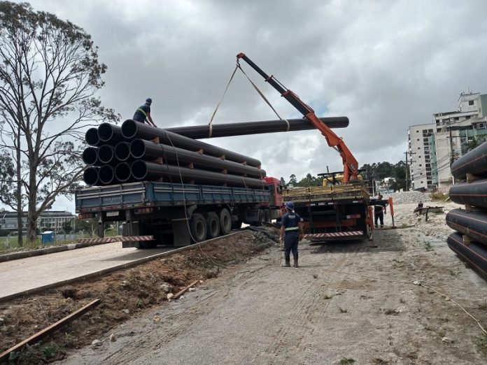 Casan inicia implantação de emissário no trecho em duplicação na Edu Vieira - caminhão munck retira canos de outro caminhão
