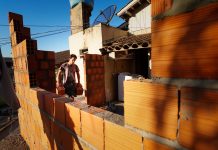 SC Mais Moradia Governo lança programa para combater déficit habitacional - homem carrega tijolos em obra