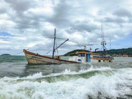 Barco encalhado há três semanas na Pinheira vaza óleo e responsável é multado