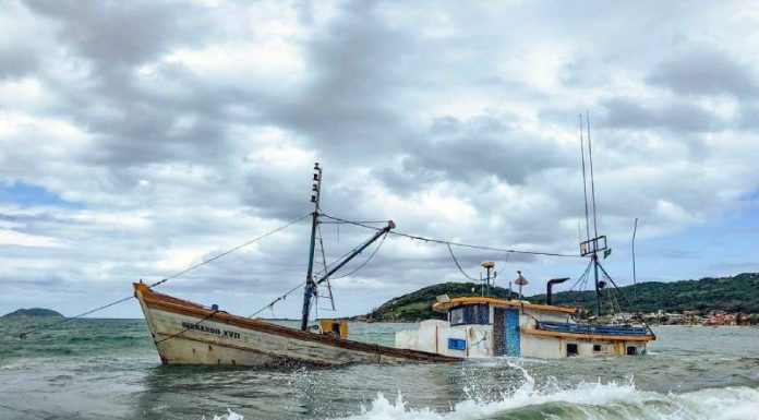 Barco encalhado há três semanas na Pinheira vaza óleo e responsável é multado