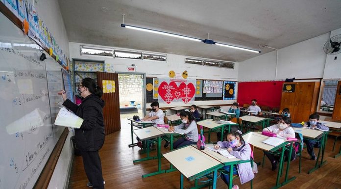 professora em sala de aula com alunos afastados e todos de máscara - descompactaçaõ da tabela do magistério em pauta em santa catarina