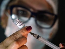 vacinação de reforço contra coronavírus na grande florianópolis - enfermeira retira dose de ampola com seringa