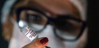 vacinação de reforço contra coronavírus na grande florianópolis - enfermeira retira dose de ampola com seringa