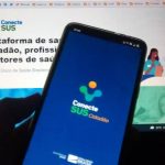 celular com aplicativo conectesus utilizado para comprovante de vacinação em frente a tela de computado com site do conectesus