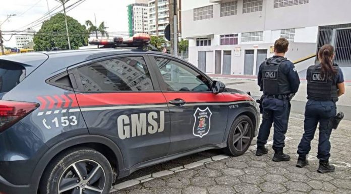 dois agentes da gmsj de costas para foto - Guarda de São José salva garota de 13 anos pendurada no terceiro andar de prédio