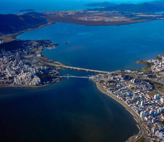 Grande Florianópolis teve crescimento de 4.400 empregos no bimestre Grande Florianópolis - vista aérea das pontes com ilha e continente e grande parte da foto ocupada pelo mar