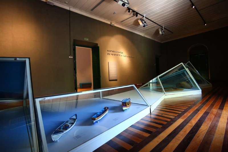 instalações dentro do museu com miniaturas de baleeiras em sala com iluminação por spots - Museu de Florianópolis Sergio Grando, na Praça XV, é aberto ao público