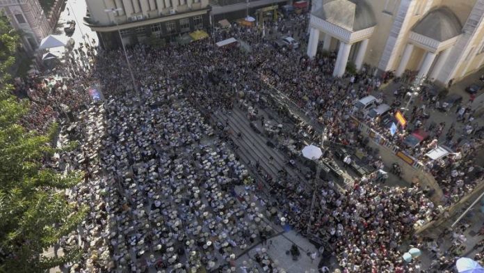 imagem de aérea de centena de bateristas tocando em orquestra no largo da catedral em florianópolis com grande público em volta