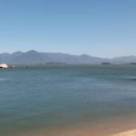 mar da praia de itaguaçu e serra do tabuleiro ao fundo em dia de céu limpo