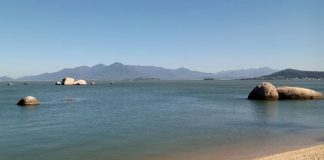 mar da praia de itaguaçu e serra do tabuleiro ao fundo em dia de céu limpo