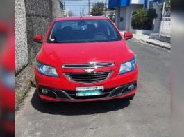 veículo gm onix vermelho estacionado em rua de asfalto utilizado na fuga dos presidiário que escaparam em Florianópolis