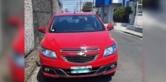 veículo gm onix vermelho estacionado em rua de asfalto utilizado na fuga dos presidiário que escaparam em Florianópolis