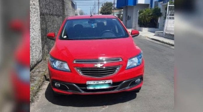 veículo gm onix vermelho estacionado em rua de asfalto utilizado na fuga dos presidiário que escaparam em Florianópolis