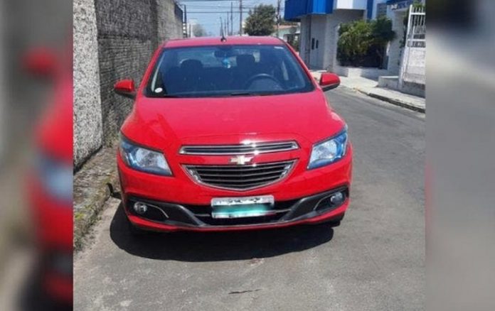 veículo gm onix vermelho estacionado em rua de asfalto utilizado na fuga dos presidiário que escaparam em Florianópolis
