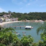 foto de orla de pequena praia com muitos barcos na enseada e trapiche em construção; morros verdes em volta - TCE aponta irregularidades e determina fim de contrato do pedágio ambiental de Governador Celso Ramos