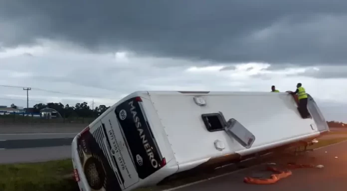 ônibus tombado em 45º no canteiro central sobre lateral direita - Acidente com ônibus de turismo em Laguna deixa criança gravemente ferida