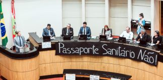 bancada da alesc dos deputados antivacinas com faixa à frente inscrita "passaporte sanitário não"