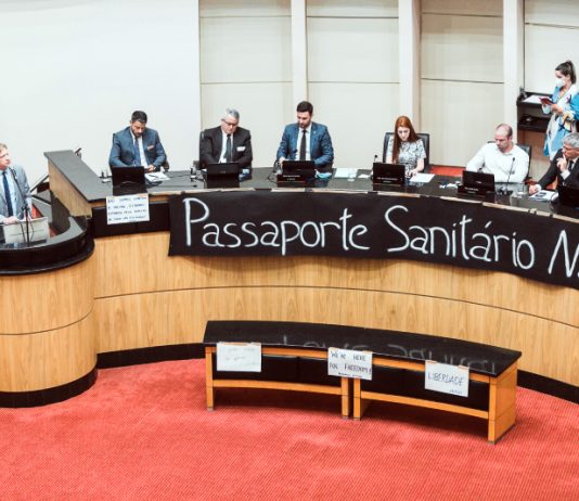 bancada da alesc dos deputados antivacinas com faixa à frente inscrita "passaporte sanitário não"