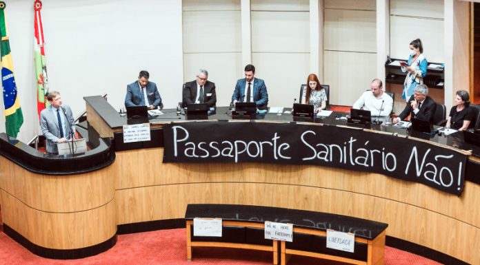bancada da alesc dos deputados antivacinas com faixa à frente inscrita "passaporte sanitário não"