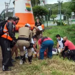 equipes de resgate retirando corpo ao lado de barrando com árvores - Motociclista morre em frente ao posto policial da SC-401