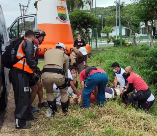 Motociclista morre em frente ao posto policial da SC-401 equipes de resgate retirando corpo ao lado de barrando com árvores - Motociclista morre em frente ao posto policial da SC-401