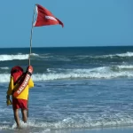salva vidas coloca bandeira vermelha na praia do campeche em florianópolis