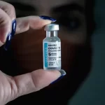 mulher segura dose de vacina da pfizer contra covid