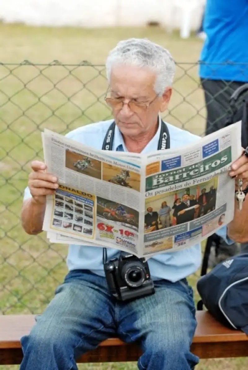 orestes lendo o jornal de barreiros onde a manchete é "os pesadelos de fernando elias"