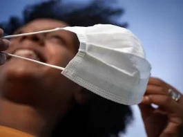 Uso de máscaras deixa de ser obrigatório em Santa Catarina mulher retira a máscara sorridente - uso de máscara deixa de ser obrigatório em sc