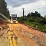 caminhão passando por parte da pista da sc-108 ao lado de queda de barreira