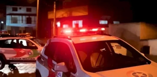 Duas pessoas são assassinadas em ato de vingança no bairro Carianos viatura policial com giroflex ligado - ocorrência crime homicídio PM