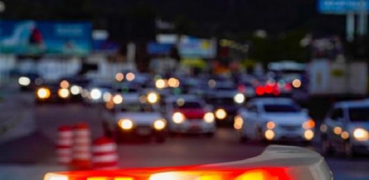 Balanço aponta redução de assassinatos e prisão de 6 mil pessoas em SC giroflex de uma viatura ligado em destaque com carros passando em avenida ao fundo