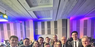 Foto mostra deputados e senadores catarinenses ao lado de representantes da Abrasel SC. Todos estão reunidos em ambiente interno, posando para a foto com sorrisos. A imagem foi feita durante o lançamento do 37º Congresso da Abrasel, em Brasília.