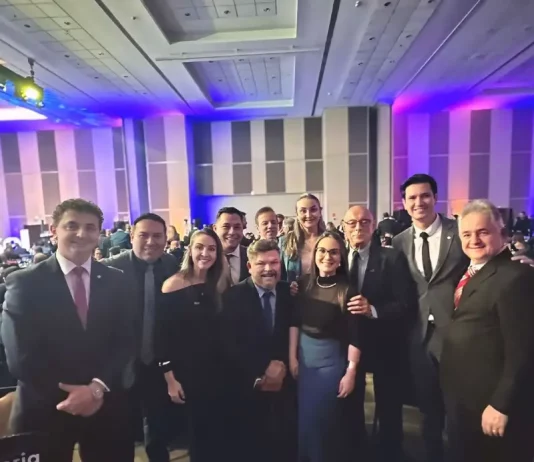 Foto mostra deputados e senadores catarinenses ao lado de representantes da Abrasel SC. Todos estão reunidos em ambiente interno, posando para a foto com sorrisos. A imagem foi feita durante o lançamento do 37º Congresso da Abrasel, em Brasília.