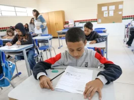 Alunos participam de avaliação em sala de aula no programa Educação Levada a Sério, enquanto a professora circula acompanhando o desempenho.