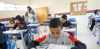 Alunos participam de avaliação em sala de aula no programa Educação Levada a Sério, enquanto a professora circula acompanhando o desempenho.