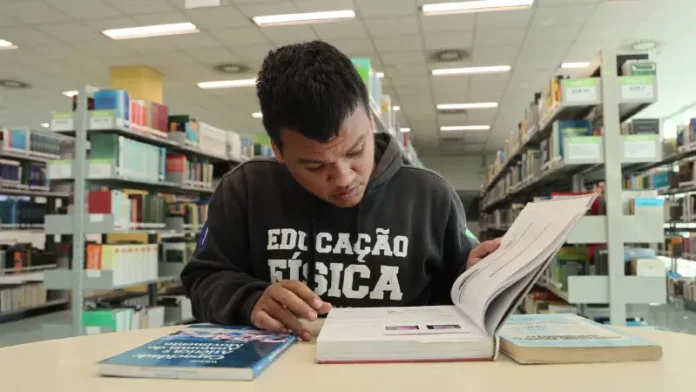 Aluno beneficiado pelo programa Universidade Gratuita, vestindo moletom marrom com a inscrição 