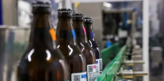 Linha de engarrafamento em cervejaria moderna, ilustrando o crescimento e a liderança de Santa Catarina na abertura de novas cervejarias.