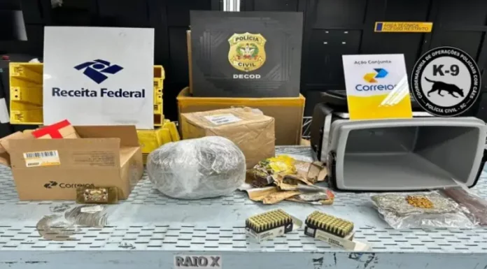 Na foto, aparecem os emblemas da Receita Federal, da Polícia Civil e dos Correios alinhados na parte superior. Abaixo, sobre uma superfície clara, estão expostas armas, munições e substâncias entorpecentes apreendidas na operação que investigou encomendas enviadas pelos Correios.