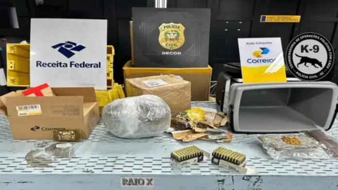 Na foto, aparecem os emblemas da Receita Federal, da Polícia Civil e dos Correios alinhados na parte superior. Abaixo, sobre uma superfície clara, estão expostas armas, munições e substâncias entorpecentes apreendidas na operação que investigou encomendas enviadas pelos Correios.