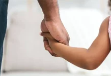 Homem segurando a mão de uma menina, representando famílias que podem solicitar isenção de IPTU em Florianópolis.