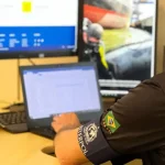 Policial da Interpol analisa informações em um computador durante investigação sobre estrangeiro preso em Florianópolis por fraudes milionárias no Chile.