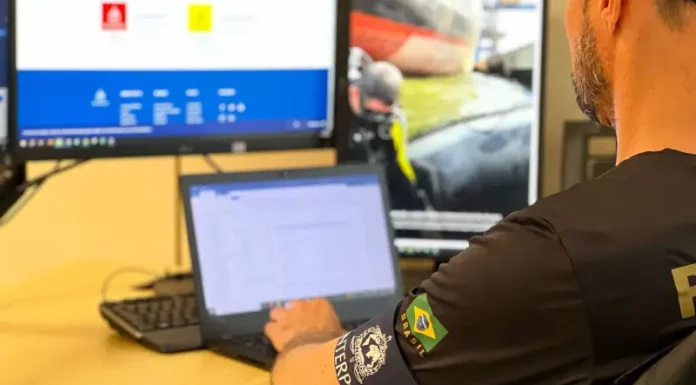 Policial da Interpol analisa informações em um computador durante investigação sobre estrangeiro preso em Florianópolis por fraudes milionárias no Chile.
