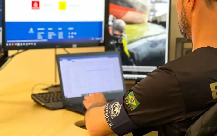 Policial da Interpol analisa informações em um computador durante investigação sobre estrangeiro preso em Florianópolis por fraudes milionárias no Chile.