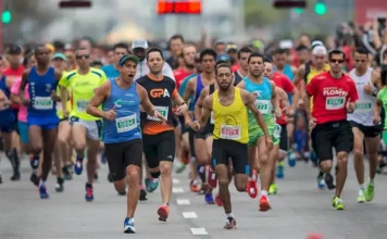 Atletas competindo na Maratona Internacional de Floripa, correndo pelo trajeto nas ruas de Florianópolis, durante as provas de 21km e 42km