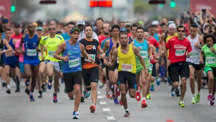Atletas competindo na Maratona Internacional de Floripa, correndo pelo trajeto nas ruas de Florianópolis, durante as provas de 21km e 42km