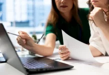 Empresárias analisando planilhas financeiras em laptop, planejando decisões estratégicas para o sucesso de novos negócios