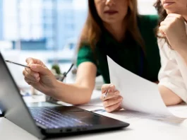 Empresárias analisando planilhas financeiras em laptop, planejando decisões estratégicas para o sucesso de novos negócios