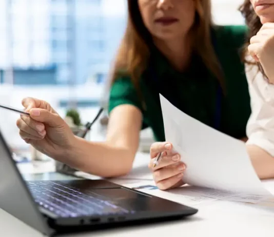 Empresárias analisando planilhas financeiras em laptop, planejando decisões estratégicas para o sucesso de novos negócios