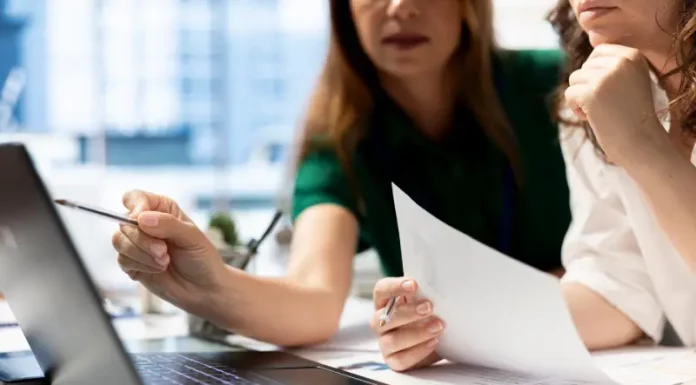 Empresárias analisando planilhas financeiras em laptop, planejando decisões estratégicas para o sucesso de novos negócios